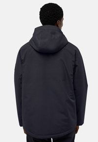 Giacca impermeabile blu scuro con cappuccio, caratterizzata da una texture liscia e un design semplice, che arriva fino a metà coscia.