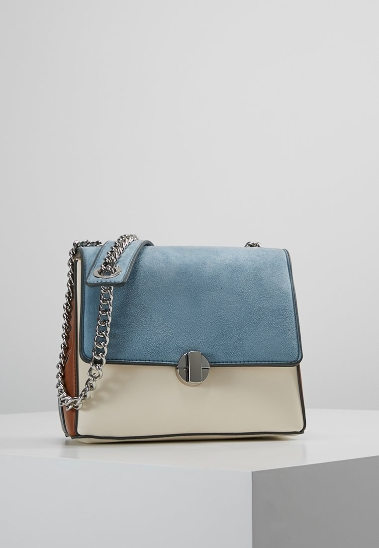 Kabelka z hladké a umělé kůže, s světle modrým vrškem, krémovým tělem a stříbrným řetízkem. Výrazné zapínání na tlačítko na předním klopě.