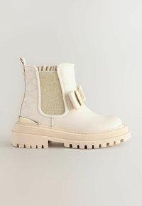 Weißer Knöchelstiefel aus glattem Leder mit seitlichen Stoffpaneelen. Besitzt eine klobige Sohle, kontrastierende Texturen und eine dekorative Schleifenakzent.