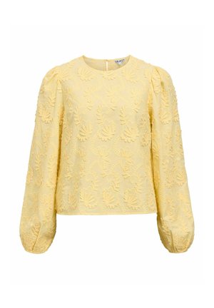 Blouse jaune brodée avec manches longues bouffantes, ornée de motifs floraux et d'un col rond, fabriquée en tissu texturé. Fermeture éclair au dos.