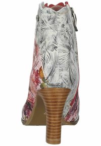 Botín floral con un exterior estampado en blanco y rosa, cierre de cremallera y un tacón apilado marrón texturizado.