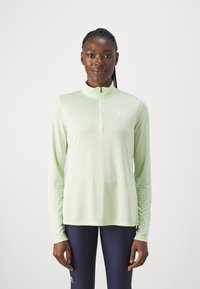 Lys grøn langærmet træningstrøje med halv-zip halsudskæring og en tætsiddende pasform. Har et diskret logo på brystet. Strækbart stof.