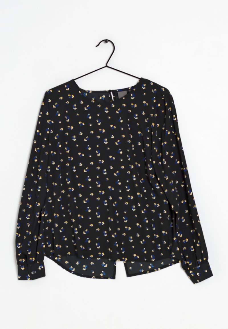 Blusa nera a maniche lunghe con piccolo motivo floreale blu, giallo e bianco. Collo rotondo e orlo leggermente curvo, realizzata in un tessuto leggero.