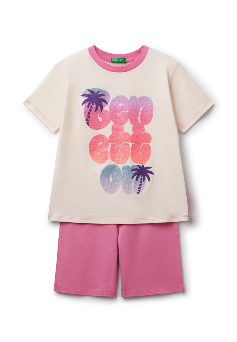 Camiseta de crema claro con ribete rosa y gráfico de palmera; combinada con pantalones cortos rosas. El material es algodón suave con una textura lisa.