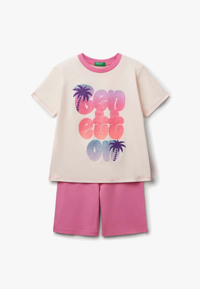Helles cremefarbenes T-Shirt mit rosa Akzenten und einem Grafikmotiv eines Palmenbaums; kombiniert mit rosa Shorts. Das Material ist weiche Baumwolle mit einer glatten Textur.