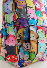 Bunter Rucksack aus strapazierfähigem Stoff mit einem lebhaften Muster von Cartoonfiguren. Beinhaltet eine vordere Reißverschlusstasche mit passendem Zugband.