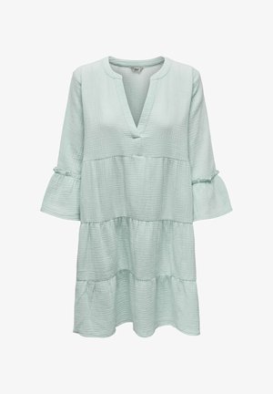Lys mintgrøn lag-på-lag kjole med tekstureret stof, V-hals og trekvart lange klokkeærmer med diskrete rufle detaljer.