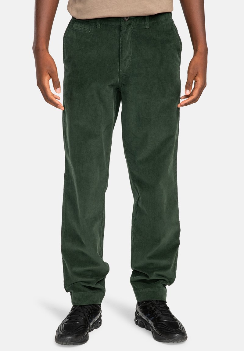 Green corduroy pants with a straight-leg design, featuring front pockets and a button closure. Smooth texture, paired with black shoes.