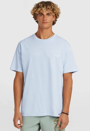 Jasnoniebieska bawełniana koszulka z krótkimi rękawami, okrągłym dekoltem i małym białym logo na lewej piersi. Gładka tekstura, luźny fason.