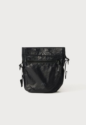 Saco impermeável preto feito de nylon texturizado, com fecho superior em zíper, bolso frontal com zíper e laterais ajustáveis com cordão.