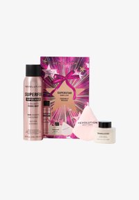 Revolution kosmetikksettet inkluderer en rosa sprayflaske, en beholder med gjennomsiktig pudder, en sminkesvamp og fargerik emballasje med stjerne mønster.