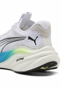 Scarpa atletica bianca con tomaia in mesh testurizzato, dettagli neri e suola sfumata blu e verde; presenta un tallone imbottito e un logo.