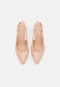 Jasnoróżowe czółenka typu slingback z ostrym noskiem, o gładkiej, błyszczącej teksturze, z regulowanym paskiem i subtelnym brandingiem wewnątrz.