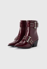 Spitze burgunderfarbene Knöchelstiefel aus glänzendem Lackleder. Mit silberner Schnalle und Riemen mit Ösen. Gestapeltes Absatzdesign.