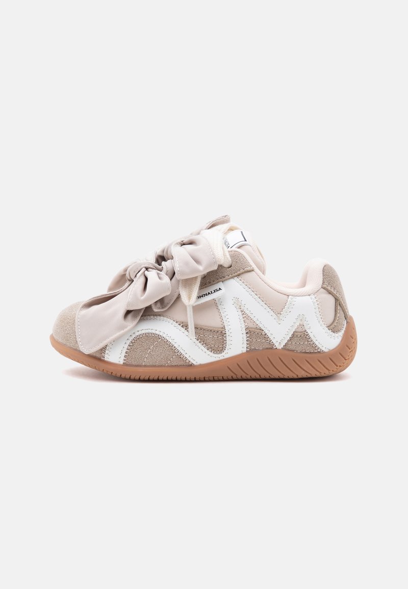 Baskets pour enfants beige et blanches avec de grands lacets en tissu en forme de nœud et semelle en caoutchouc marron, vues de côté sur fond blanc.