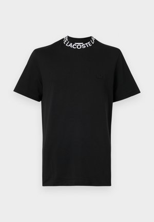 Must värvi lühikeste varrukatega T-särk ümarate kaelustega, millel on kontrastne valge "LACOSTE" logoriba. Pehme puuvillane materjal slim-fit disainiga.