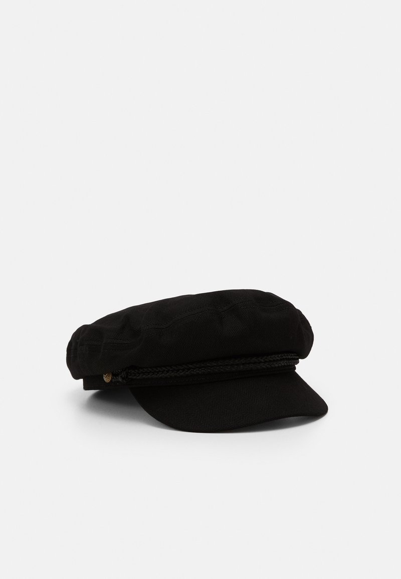 Casquette noire en coton de style capitaine avec bande tressée et petit bouton doré, posée sur une surface blanche.