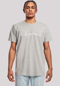 Graues Baumwoll-T-Shirt mit kurzem Ärmeldesign, das eine weiße Herzschlaglinie und eine Bergsilhouette über die Brust gedruckt hat.