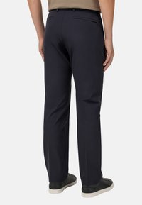 Tumed sinised püksid sirge jala disainiga, valmistatud siledast kangast. Omab kahte tagakotti, viimistletud elegantselt õmmeldud õmblustega ja vööpaeladega.