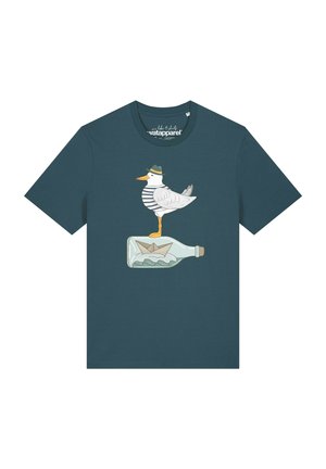 T-shirt vert sarcelle foncé avec un graphique d'une mouette portant une chemise rayée et un chapeau, debout sur une bouteille contenant un bateau en papier et des vagues.