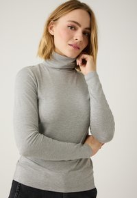 Grauer Rollkragenpullover aus weichem, elastischem Stoff mit langen Ärmeln und enger Passform. Glatte Textur, minimale Nähte und schlichtes Design.