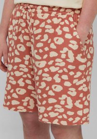 Pantaloni corti leggeri di colore ruggine con stampa leopardata crema, dotati di una vita elastica, cordoncino e tasche laterali.
