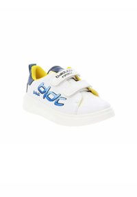 Baskets blanches avec des accents bleus et jaunes, présentant un matériau lisse, des sangles Velcro et un design à bout rond. Nom de la marque affiché sur le côté.