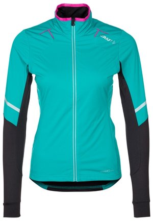 Dames lange mouwen sportjack in blauwgroen en zwart met reflecterende strepen, roze kraagafwerking, rits aan de voorkant en Craft-logo op de borst.