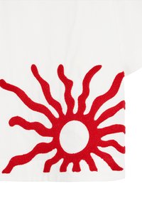 Biały materiał z dużym motywem czerwonego słońca na dolnej krawędzi, z teksturowanymi promieniami i okrągłym środkiem, tworzącym uderzający kontrast wizualny.