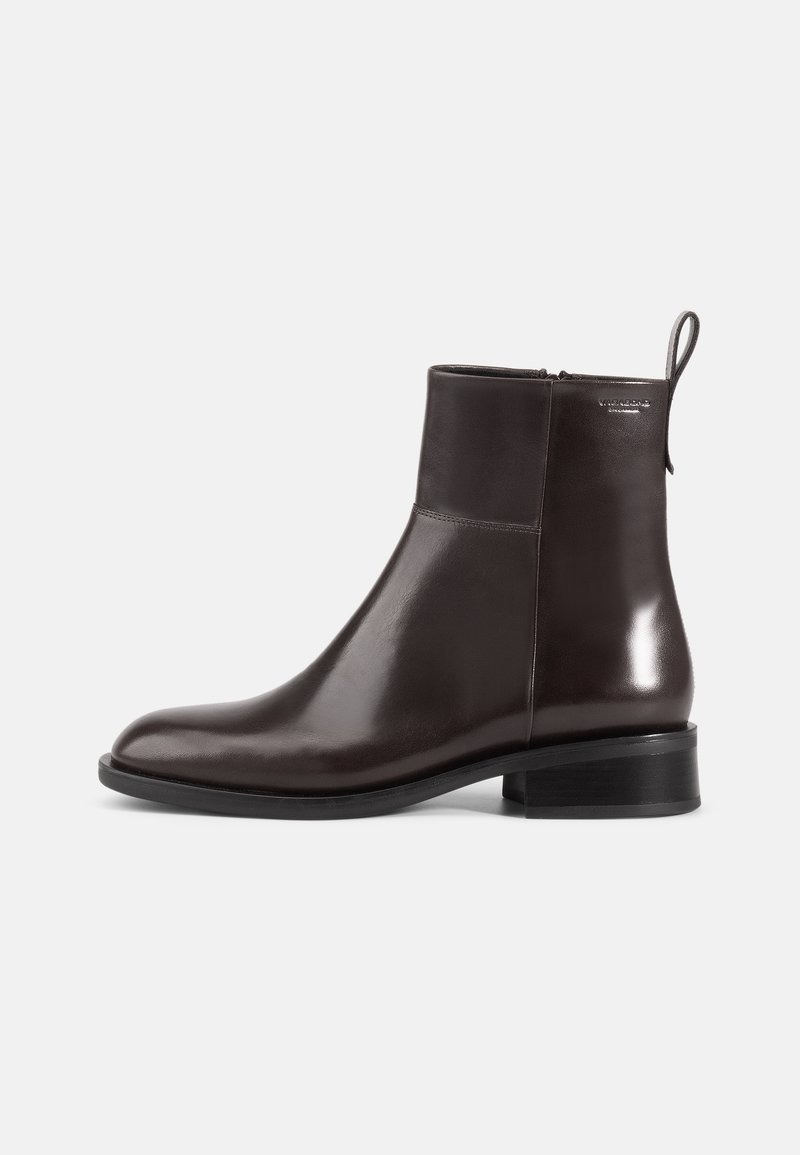 Brown leather ankle boot with a sleek design, rounded toe, low block heel, and a side zipper. Includes a pull tab at the back.