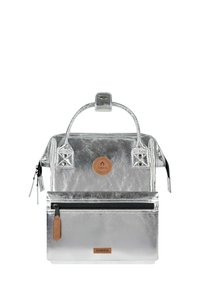 Silver metallic backpack with a top handle, front zip pocket, and brown leather accent logo. Features a structured design and shiny texture.