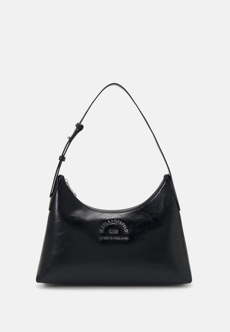 Sac à main en cuir noir avec une forme courbée et une seule bandoulière. Il possède une fermeture éclair et un logo en relief à l'avant.