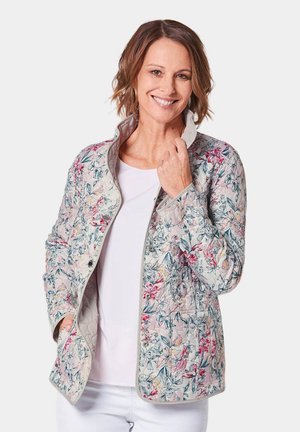 Veste matelassée florale avec un fond gris clair et des motifs de fleurs roses et bleues. Col discret et fermetures à pression.
