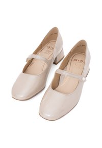 Tacones Mary Jane beige con un acabado brillante, punta redonda y un tacón bajo de bloque. Presenta una correa con un acento decorativo de botón.