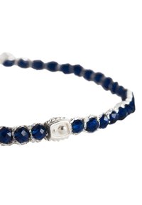 Blaues Kristallarmband mit facettierten Perlen, eingearbeitet in ein verdrehtes Silberband mit einem dekorativen Verschluss, der einen runden Akzent zeigt.