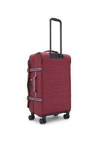 Red fabric suitcase with a textured finish, black retractable handle, two zippered side pockets, and four smooth-rolling wheels.