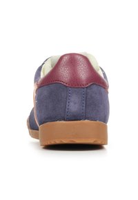 Sneaker in camoscio blu con tacco in pelle bordeaux, fodera chiara e suola in gomma beige. Forma rotonda semplice con dettagli minimi.