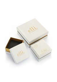 Drei Geschenkboxen in unterschiedlichen Größen, mit einem weißen Äußeren und goldener Schrift. Die innere Box ist mit Gold gefüttert und verfügt über einen gepolsterten schwarzen Einsatz.