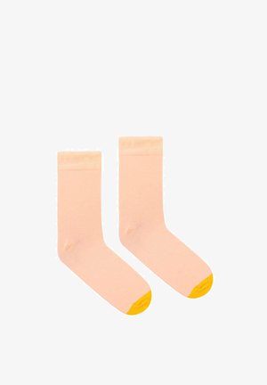 Jasnoróżowe skarpetki bawełniane z żółtą osłonką na palce. Posiadają żebrowany mankiet dla lepszego dopasowania, gładką teksturę oraz klasyczny fason typu crew.
