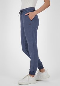 Mörkblå joggingbyxor i ett mjukt material, med elastisk midja och dragsko, sidofickor och ribbade muddar. Litet hjärtlogotypdetalj.