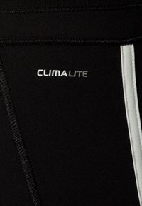 Pantaloni sportivi neri con marchio Climalite, realizzati in un tessuto testurizzato e con una striscia laterale bianca per contrasto.