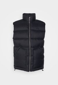 Svart puffväst med hög krage, framsida med blixtlås och två stora fickor. Har ett kviltat mönster och justerbar dragsko vid fållen.