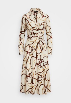 Vestido cruzado de tela crema con un patrón de cadenas y tiras marrones, con mangas largas, un cuello y un cinturón a juego para el cierre.