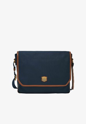 Sac messager bleu marine avec un tissu texturé, des accents en cuir brun et un rabat à l'avant. Il comporte un emblème doré et une bandoulière réglable.