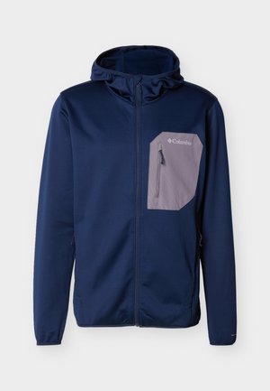 Tmavě modrá bunda s kapucí, předním zipem a světle šedým zipovaným náprsním kapsou s nápisem "Columbia".