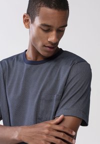 Marinrandig t-shirt med rund halsringning, korta ärmar och bröstficka. Mjuk textur och lätt tyg.