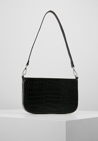 Svart läderhandväska med krokodilprägling och en rundad form, med en smal axelrem och metall detaljer.