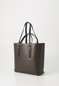 Brun mönstrad toteväska med svarta syntetläderhandtag, med en geometrisk design och metalliska detaljer för extra finish.