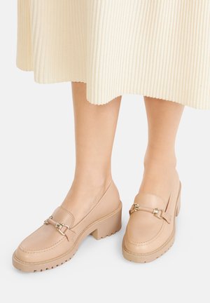 Beige Leder-Loafers mit Blockabsatz und dekorativem goldfarbenem Beschlag, mit niedrig geschnittenem Design und profilierter Gummisohle.