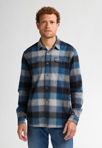 Cămașă din flanel pentru bărbați, cu un model în carouri albastre și gri, având două buzunare pe piept, închidere cu butoane și mâneci lungi. Textură moale și croială lejeră.